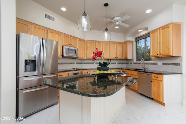 kitchen with a ceiling fan, visible vents, dark stone counters, a sink, and stainless steel appliances