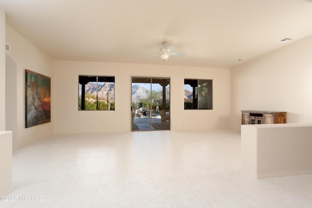 unfurnished room featuring light tile patterned flooring, a ceiling fan, and visible vents