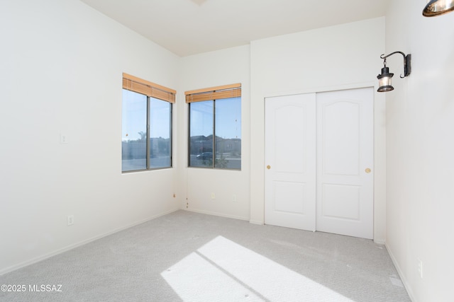 unfurnished bedroom with a closet, baseboards, and carpet flooring