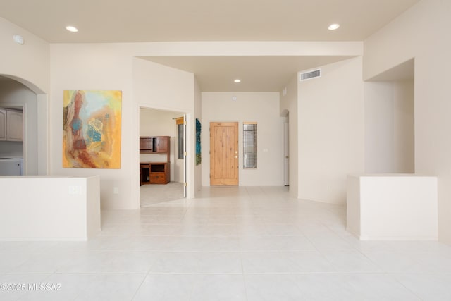 hallway with recessed lighting, arched walkways, visible vents, and light tile patterned floors