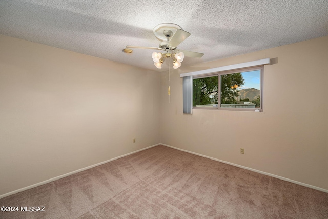 unfurnished room with ceiling fan, carpet, baseboards, and a textured ceiling