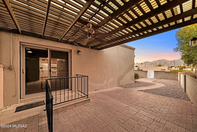 view of patio / terrace featuring a mountain view, a pergola, a fenced backyard, and a ceiling fan