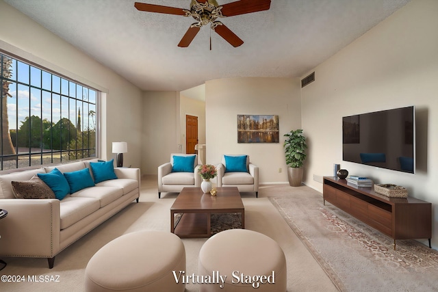 carpeted living area with ceiling fan, baseboards, visible vents, and a textured ceiling