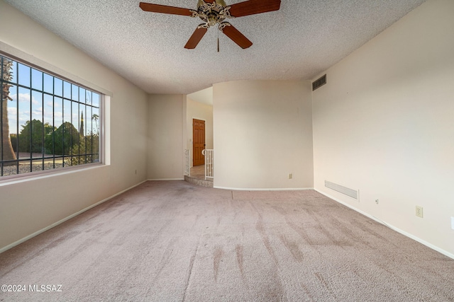 spare room featuring baseboards, visible vents, a textured ceiling, and carpet