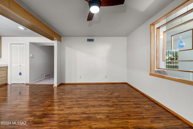 spare room with wood finished floors, visible vents, and baseboards