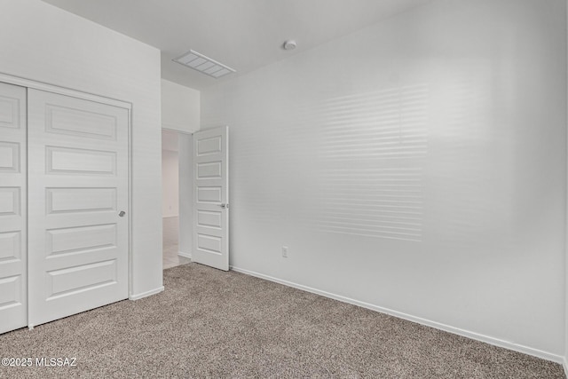 unfurnished bedroom featuring light carpet, visible vents, baseboards, and a closet