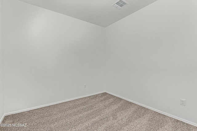 carpeted empty room featuring visible vents and baseboards