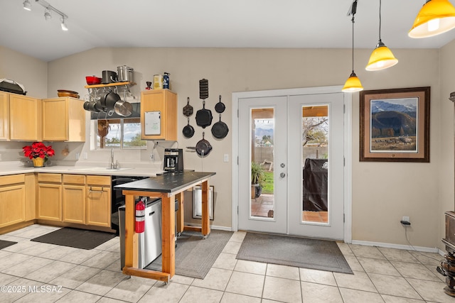 kitchen featuring light brown cabinets, light tile patterned floors, french doors, and lofted ceiling