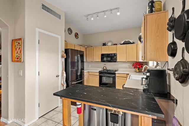 kitchen with light tile patterned floors, visible vents, a sink, light brown cabinetry, and black appliances