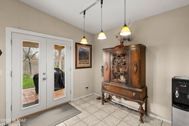 doorway featuring light tile patterned floors, french doors, and baseboards