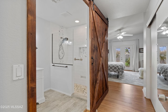 ensuite bathroom with wood finished floors, ensuite bathroom, and a walk in shower