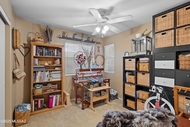 carpeted home office featuring ceiling fan