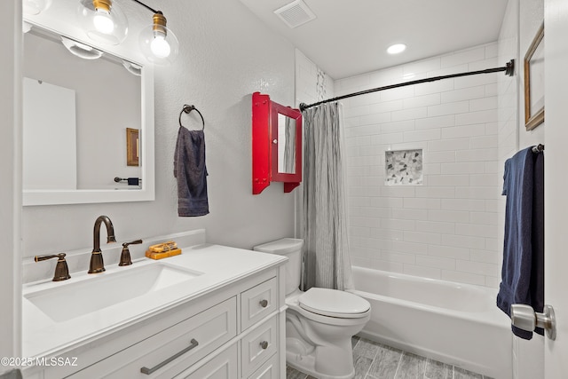 bathroom with vanity, wood finished floors, visible vents, shower / bath combo with shower curtain, and toilet