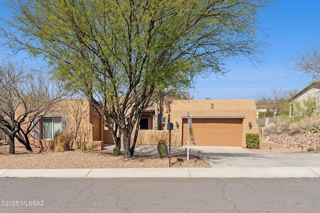 southwest-style home featuring stucco siding, driveway, and a garage