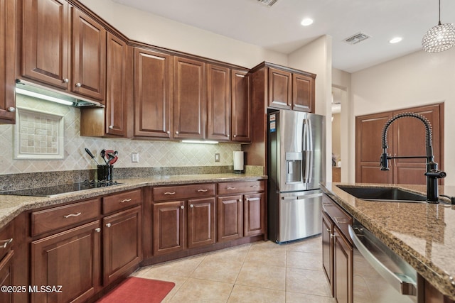 kitchen with light tile patterned floors, light stone countertops, visible vents, a sink, and stainless steel appliances