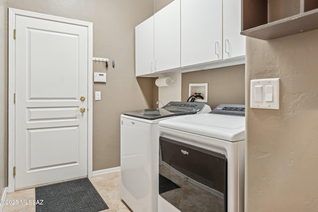 laundry room with light tile patterned floors, baseboards, cabinet space, and separate washer and dryer