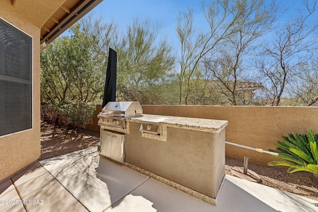 view of patio with area for grilling and a grill