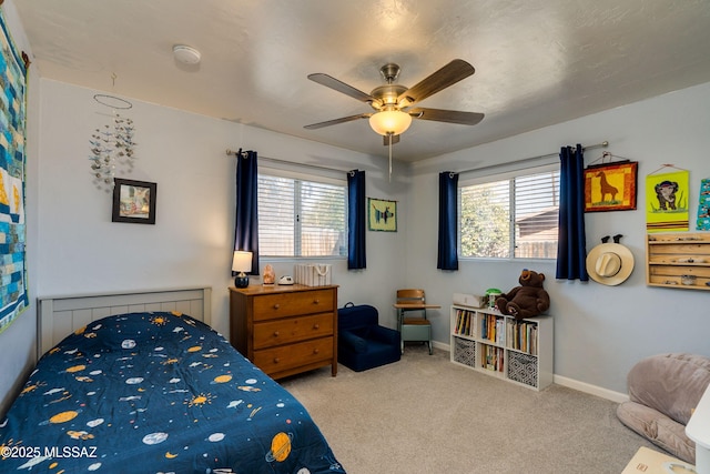 carpeted bedroom with ceiling fan and baseboards