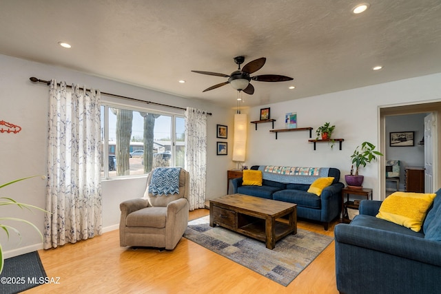 living area featuring baseboards, recessed lighting, wood finished floors, a textured ceiling, and a ceiling fan