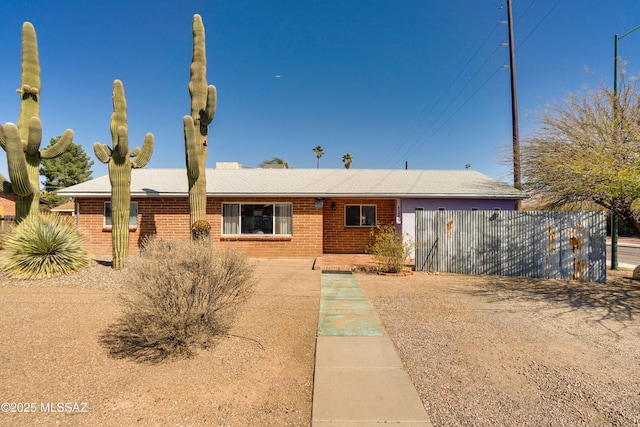 single story home with fence and brick siding