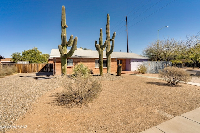 single story home featuring brick siding and fence