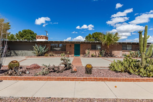 ranch-style house featuring brick siding