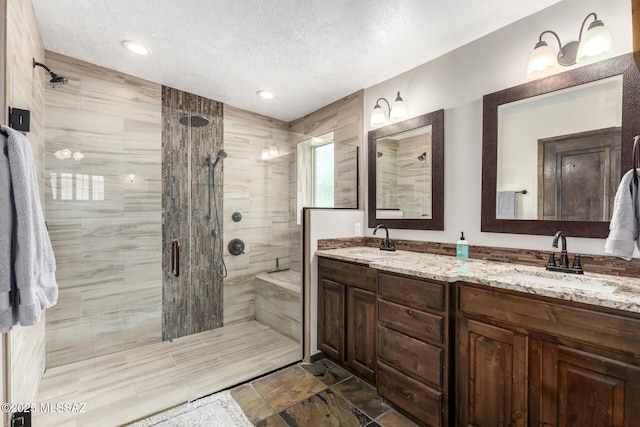 full bath with a shower stall, double vanity, and a sink