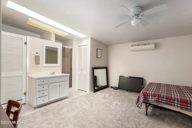 bedroom with light carpet, a ceiling fan, a sink, a wall unit AC, and light tile patterned floors