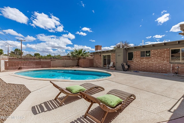 view of swimming pool with a patio area, a fenced in pool, and fence