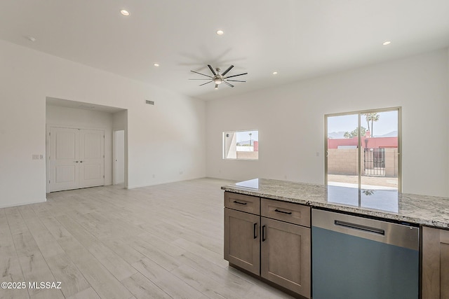 kitchen with light wood finished floors, ceiling fan, light stone countertops, open floor plan, and dishwasher