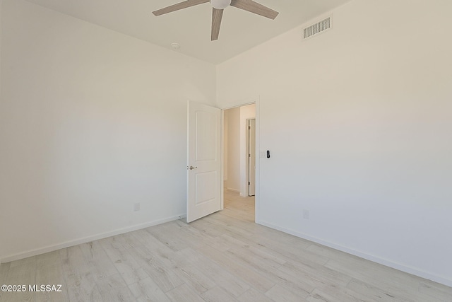 spare room with visible vents, light wood-style flooring, baseboards, and a ceiling fan