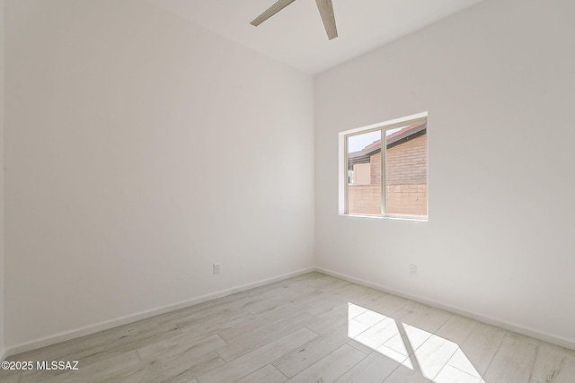 spare room with light wood-type flooring, baseboards, and ceiling fan