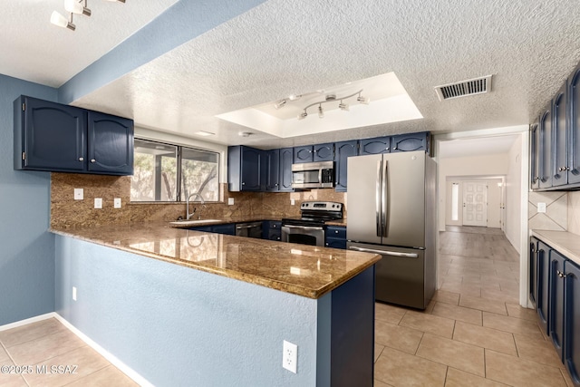 kitchen with decorative backsplash, a peninsula, visible vents, and stainless steel appliances