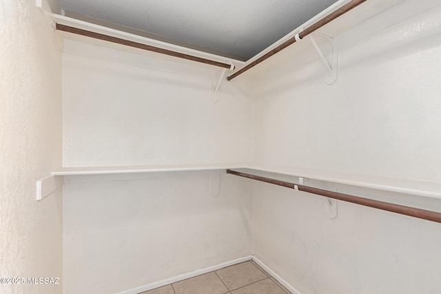 spacious closet with light tile patterned floors