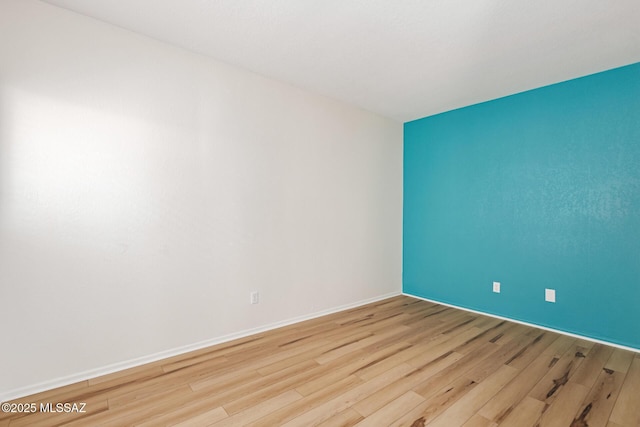 unfurnished room featuring wood finished floors and baseboards