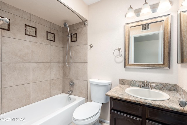 bathroom featuring visible vents, toilet, vanity, and shower / tub combination