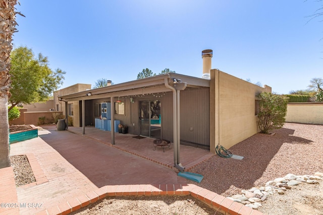 rear view of property with a fenced backyard and a patio area