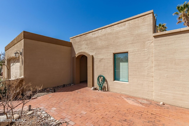 exterior space featuring stucco siding and a patio area