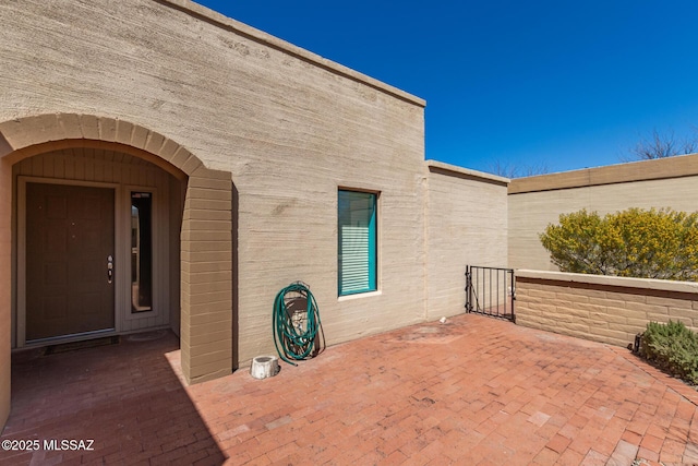 view of exterior entry featuring a patio area