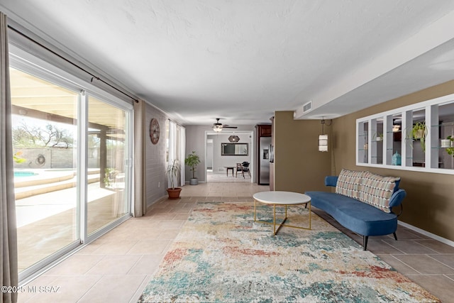 living room with visible vents, baseboards, and a ceiling fan