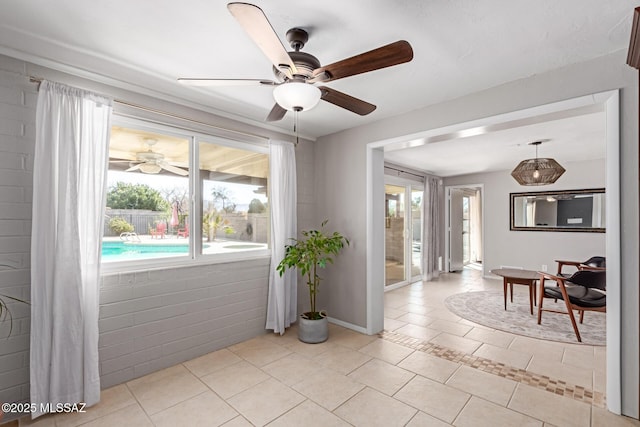 interior space featuring a wealth of natural light, baseboards, a ceiling fan, and light tile patterned flooring