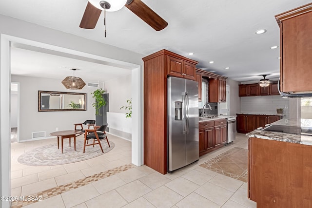 kitchen featuring tasteful backsplash, visible vents, light tile patterned flooring, stainless steel appliances, and a sink