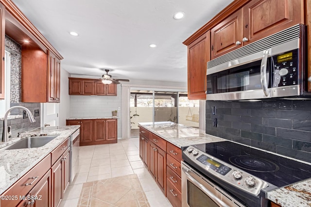 kitchen with light stone countertops, appliances with stainless steel finishes, and a sink