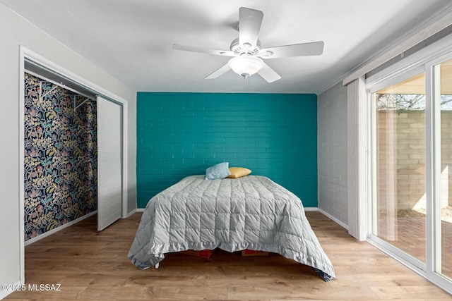 bedroom featuring baseboards, wood finished floors, and a ceiling fan