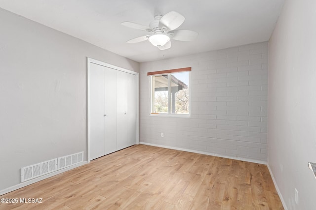 unfurnished bedroom with a closet, visible vents, baseboards, and light wood-style floors