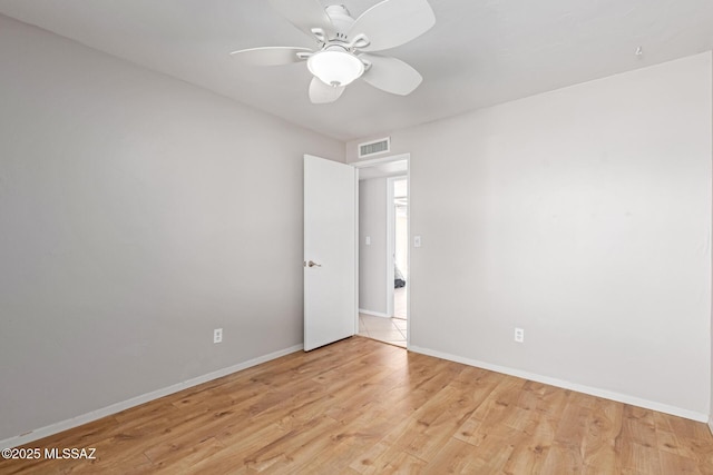 empty room featuring visible vents, light wood-style flooring, a ceiling fan, and baseboards