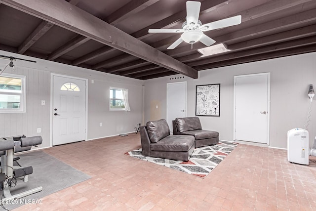 living area featuring beam ceiling and ceiling fan