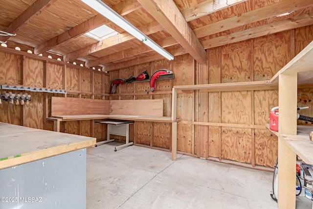 miscellaneous room featuring unfinished concrete floors and wood walls