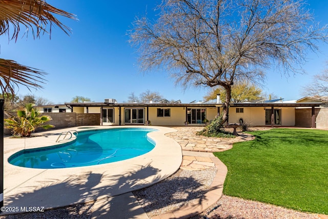 view of swimming pool featuring a fenced in pool, a patio, a lawn, and a fenced backyard