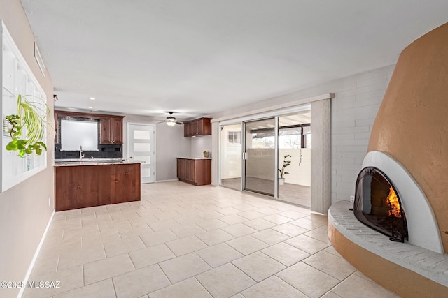 kitchen featuring light countertops, a brick fireplace, plenty of natural light, and open floor plan